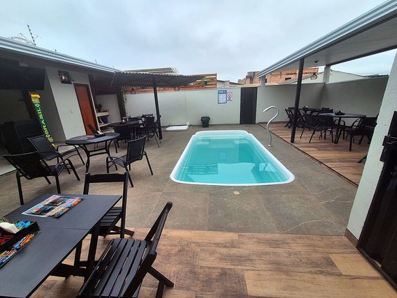 Piscina e mesas na área de lazer do Hotel Capelari